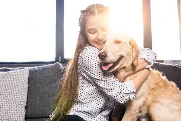 a lovely little girl hugging her dog