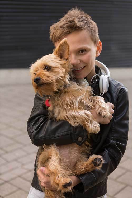 a cute boy holding his dog